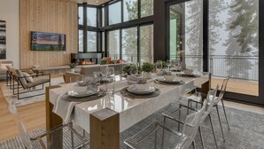 A modern dining area with a long table set for six, large windows, and a fireplace. - Boulder Place Lookout At Northstar - TLUXP (Truckee)