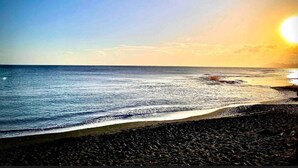 A beach with a rocky shoreline and calm sea. - Moehani Beach Lodge (Puna'auia)