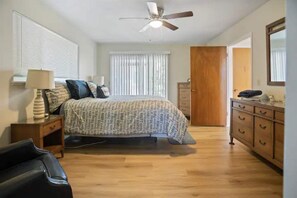 A bedroom with a bed, a nightstand, a dresser, and a ceiling fan. - "Merced Manor: Luxurious 6BR Home for Ultimate Comfort and Convenience" (Merced)