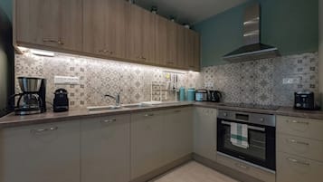 A kitchen with wooden cabinets, a stainless steel range hood, and a patterned backsplash.
