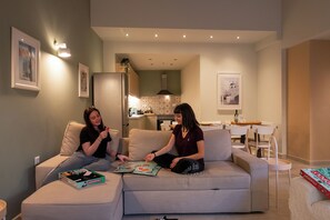 Una sala de estar con un sofá, una mesa de comedor y una cocina al fondo.