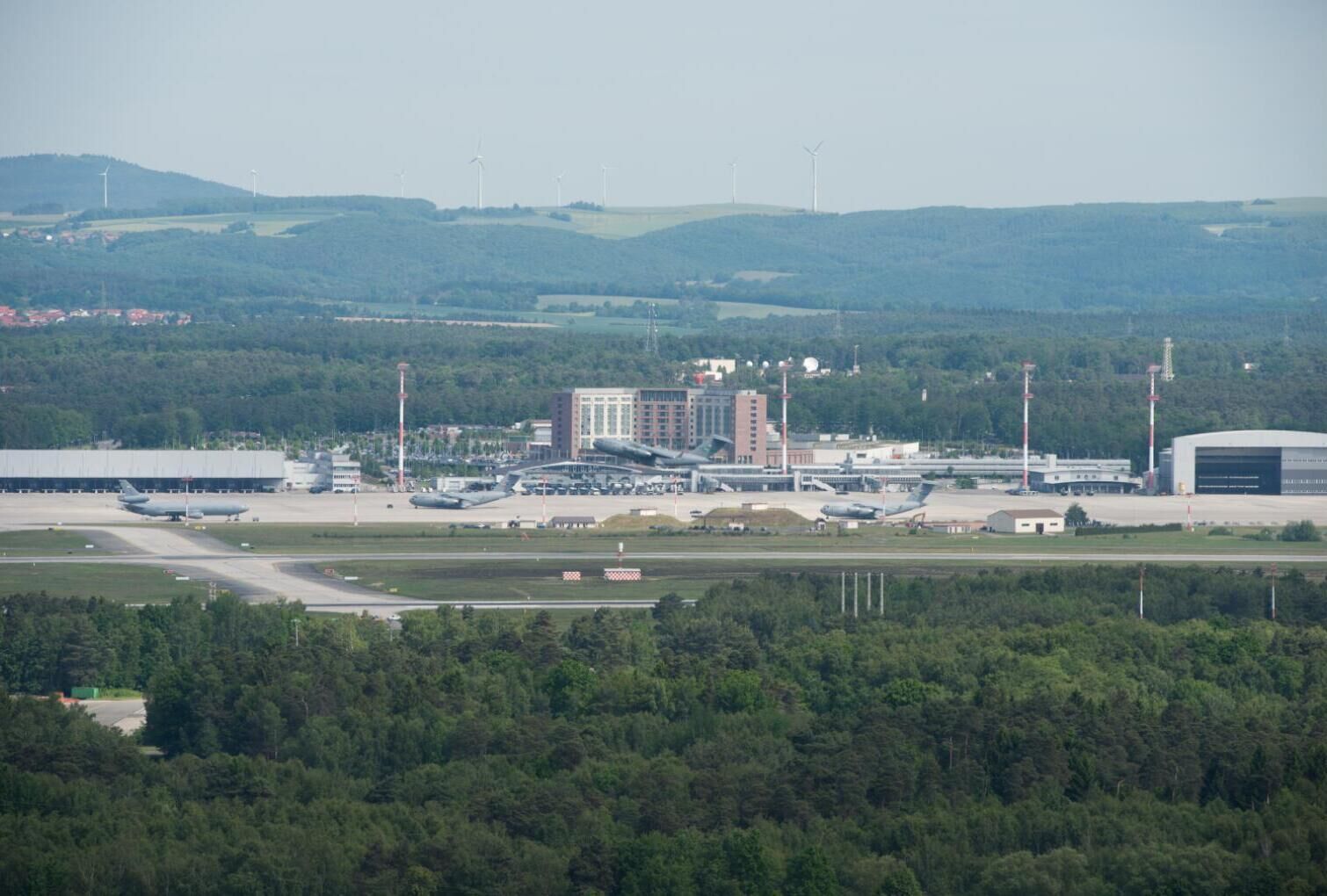 An airport with multiple runways, hangars, and a large terminal building.