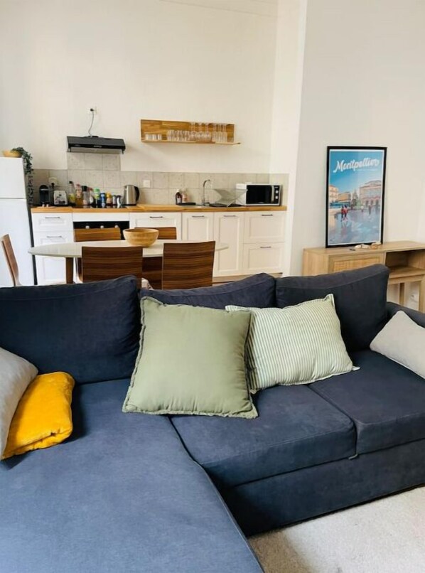 Relax in this inviting living room with a sofa, kitchenette, and city view.