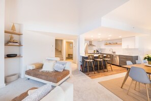 A modern apartment with a living area, kitchen, and dining space.