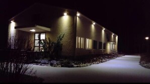 A modern house with a well-lit exterior, large windows, and a visible front porch. - Hotelli Immalanjärvi (Imatra)
