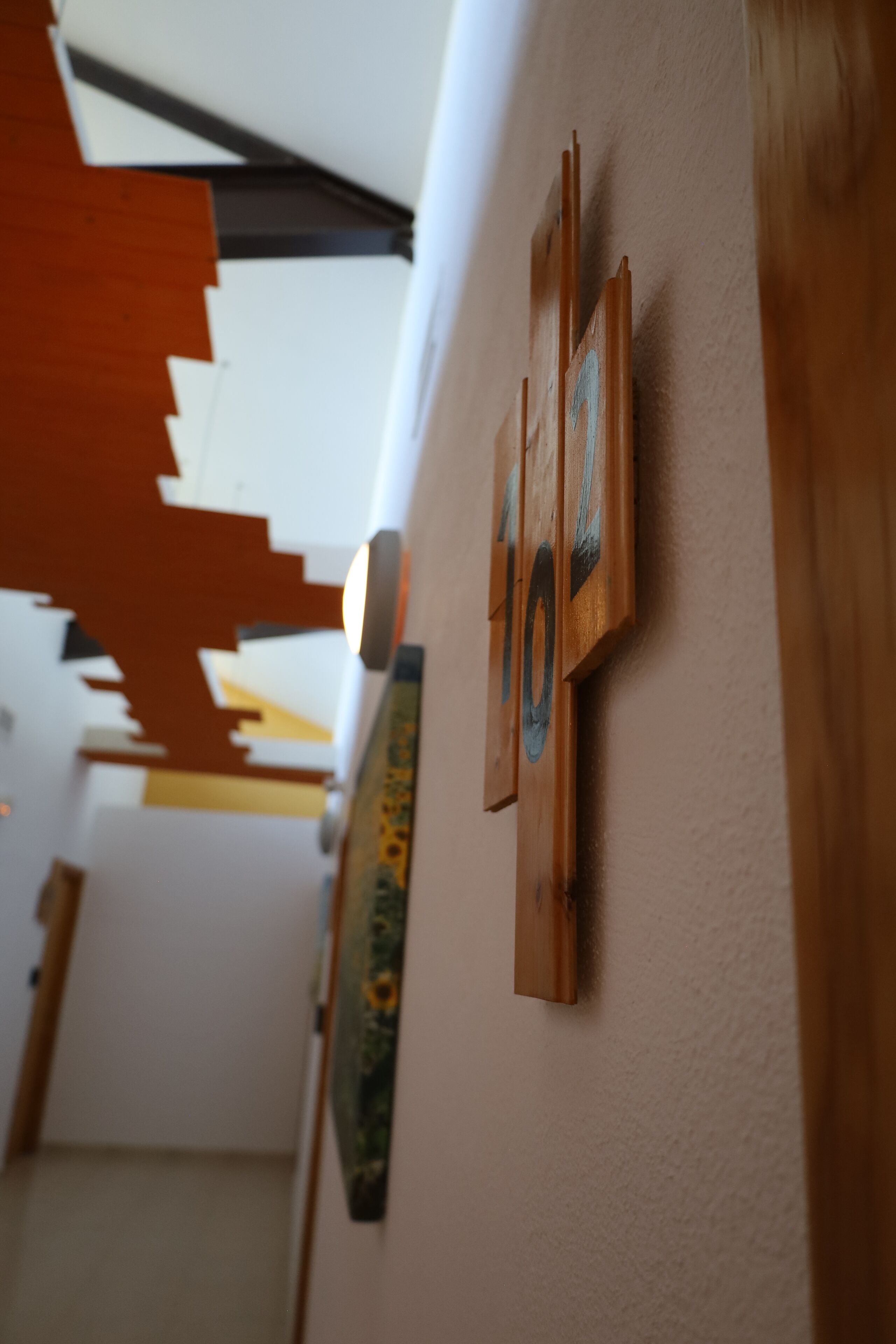 A hallway with a wooden wall decoration and a painting.