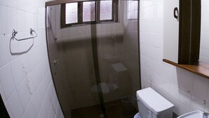 A small bathroom with a shower, toilet, and sink. - Recanto Monte Suíço (Campos do Jordão)