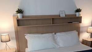 Une chambre à coucher avec un lit, deux tables de chevet et une commode.
