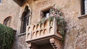 Un bâtiment historique doté d’un balcon orné de sculptures en pierre et de motifs floraux.
