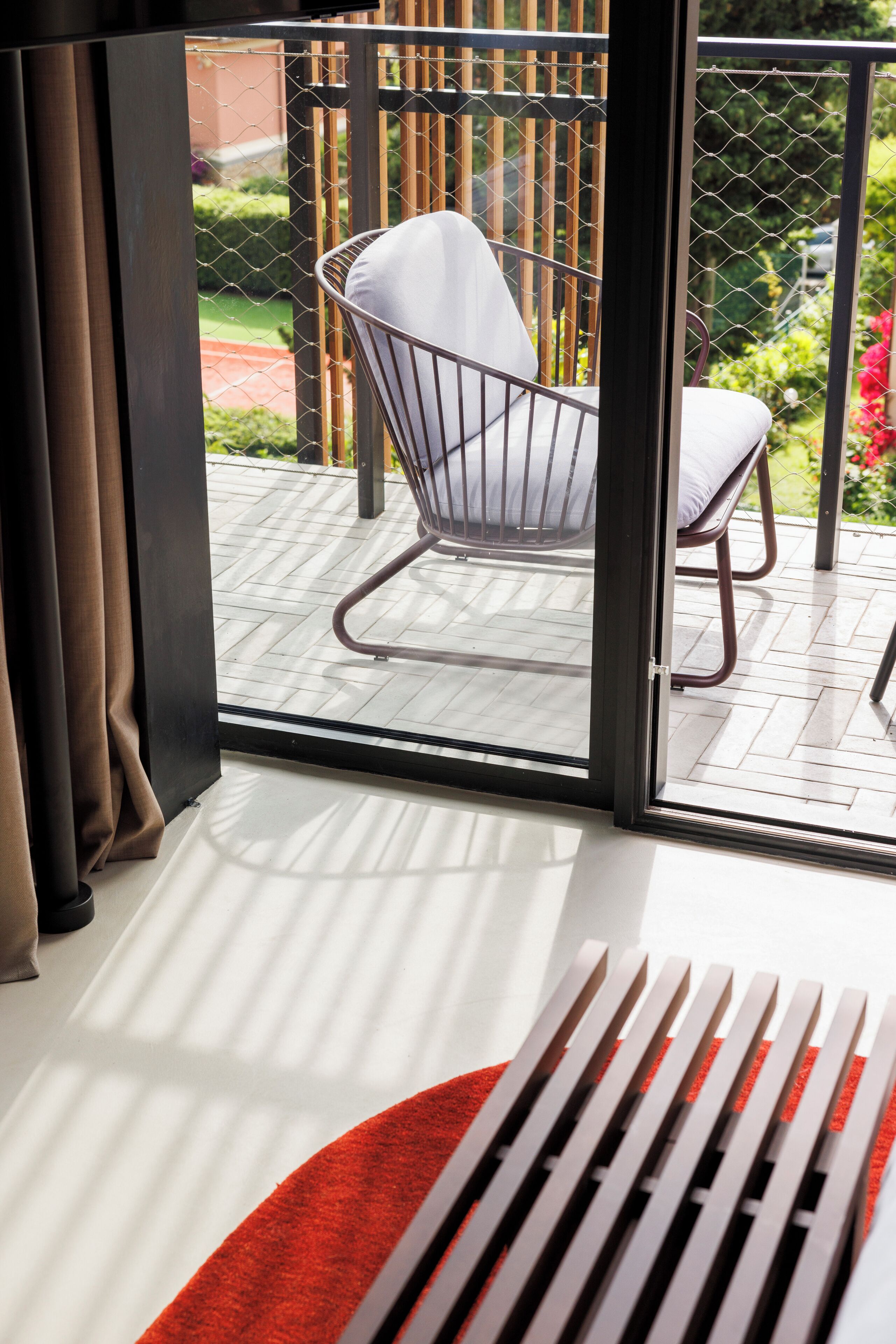 Una habitación moderna con un amplio ventanal corredero que da a un patio exterior.
