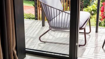 Una habitación moderna con un amplio ventanal corredero que da a un patio exterior.