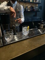 Een bar waarin een bartender drankjes bereidt.