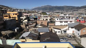 A residential area with various buildings, including a yellow building with a blue roof and a white building with a red door. - Suite Toty EN Renta (Quito)