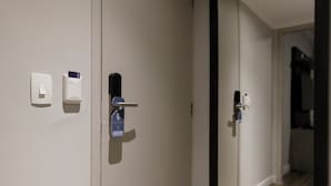 Une chambre moderne dotée d’une porte coulissante, d’un interrupteur et d’un miroir qui reflète l’intérieur.