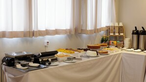 Une table de buffet proposant divers plats et un coin café.