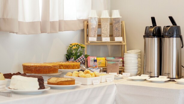 Een buffet met diverse etenswaren en koffieautomaten.