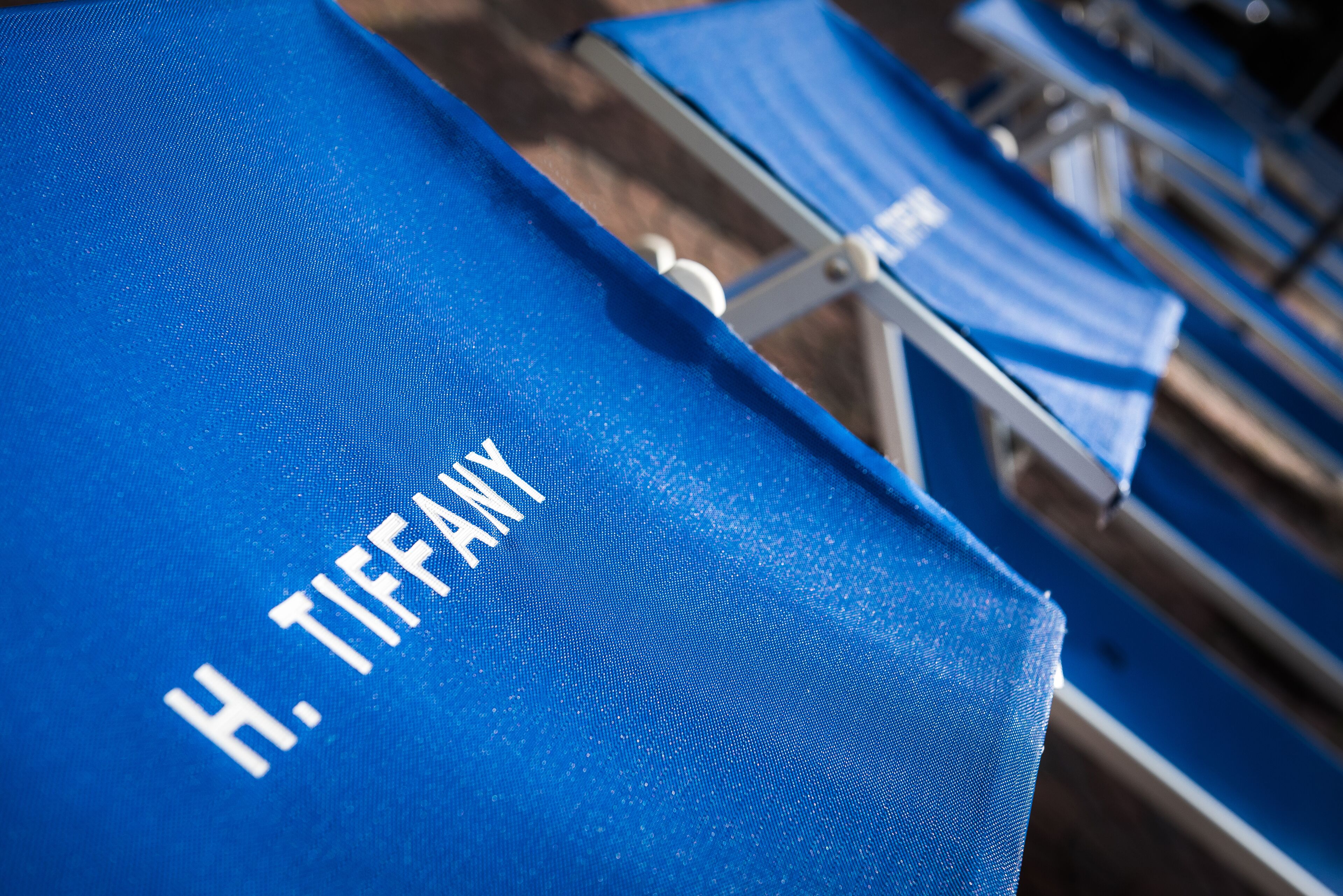 Primer pla d'una para-sol blau amb el text "H. TIFFANY".