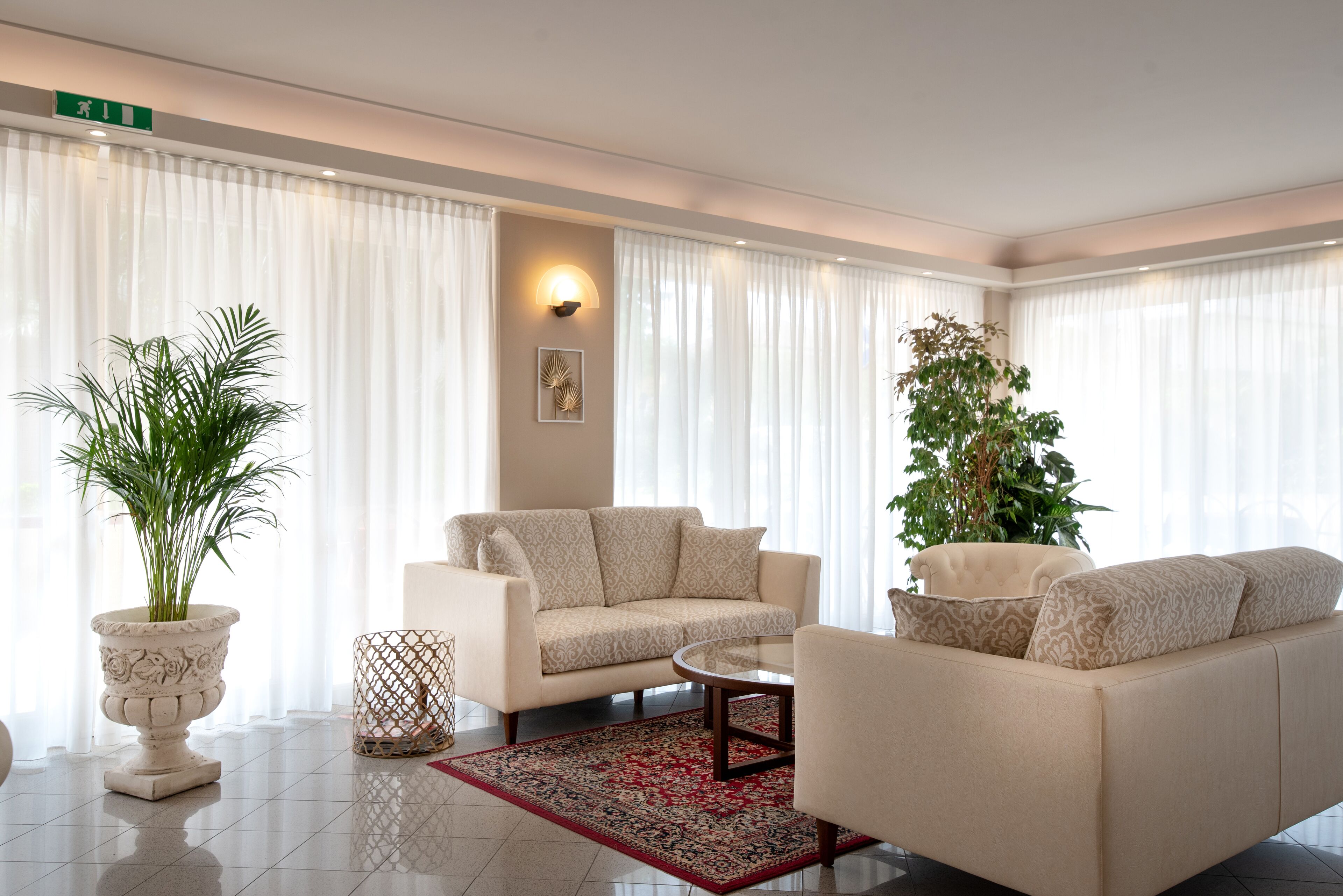 A modern living room with a beige sofa, a round coffee table, and a potted plant.