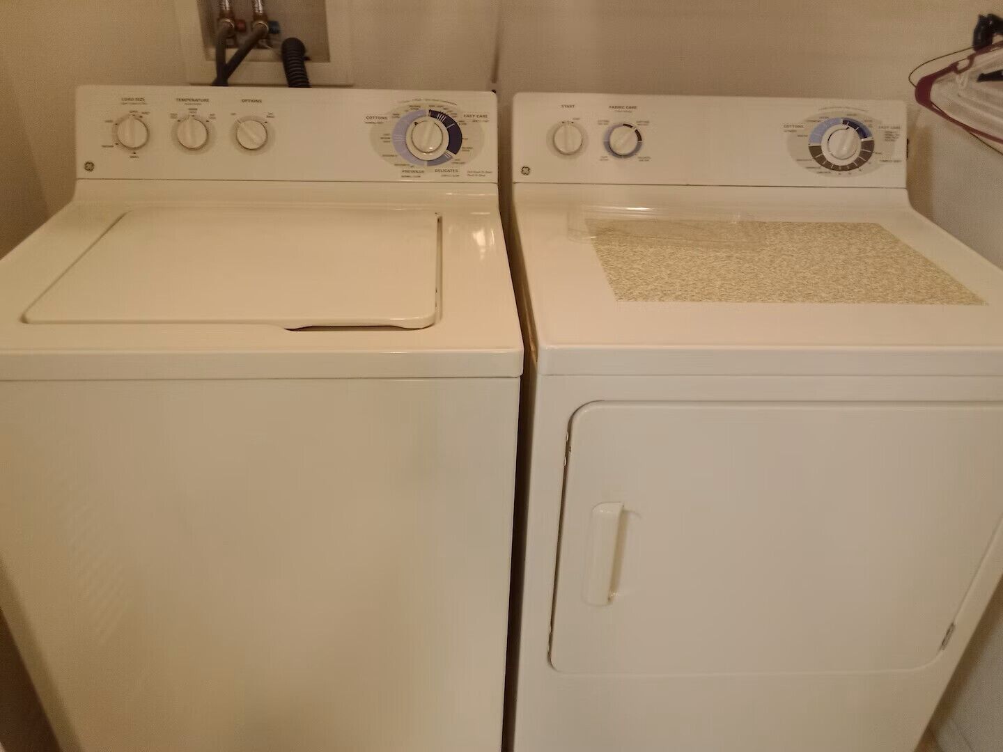 Two white front-loading washing machines side by side in a laundry room.