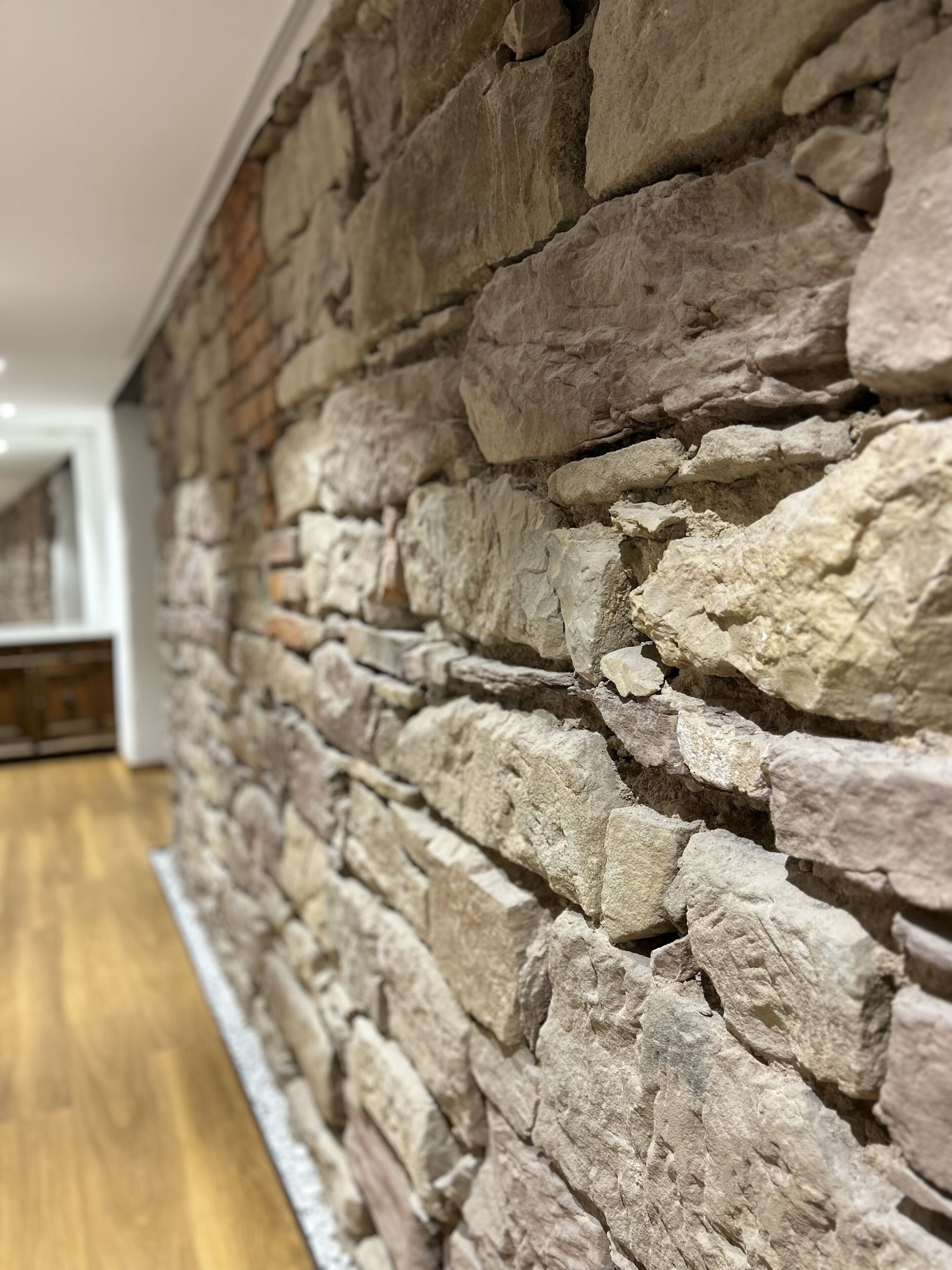 A stone wall with a wooden floor.