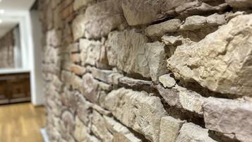 A stone wall with a wooden floor.