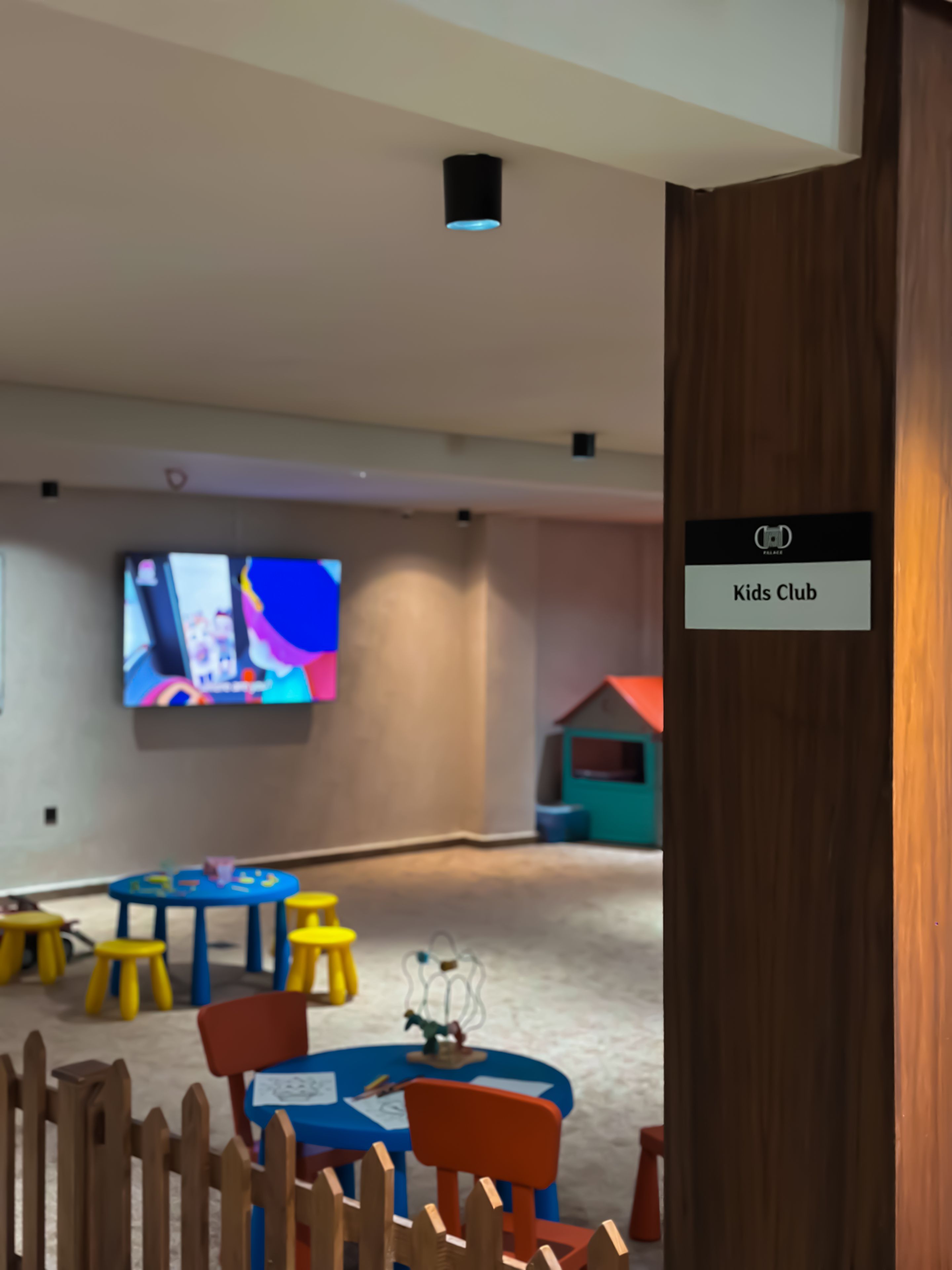 A children's play area with tables, chairs, and a television.