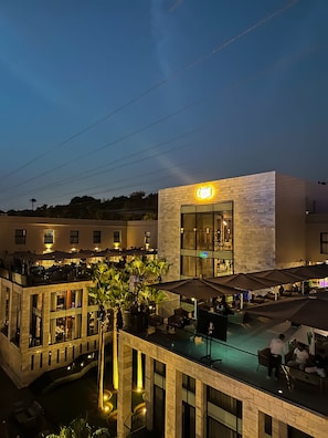 A hotel with outdoor seating, a pool, and a well-lit entrance. - Dominium Palace (Agadir)