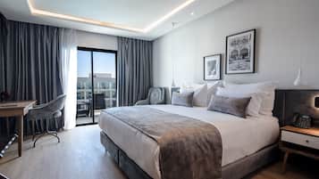 Quarto de hotel moderno com uma cama grande, uma escrivaninha e uma cadeira.