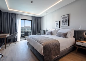 Una habitación de hotel moderna con una cama grande, un escritorio y una silla.