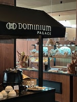 Zona de exhibición de alimentos con cestas de pan y una máquina de café.