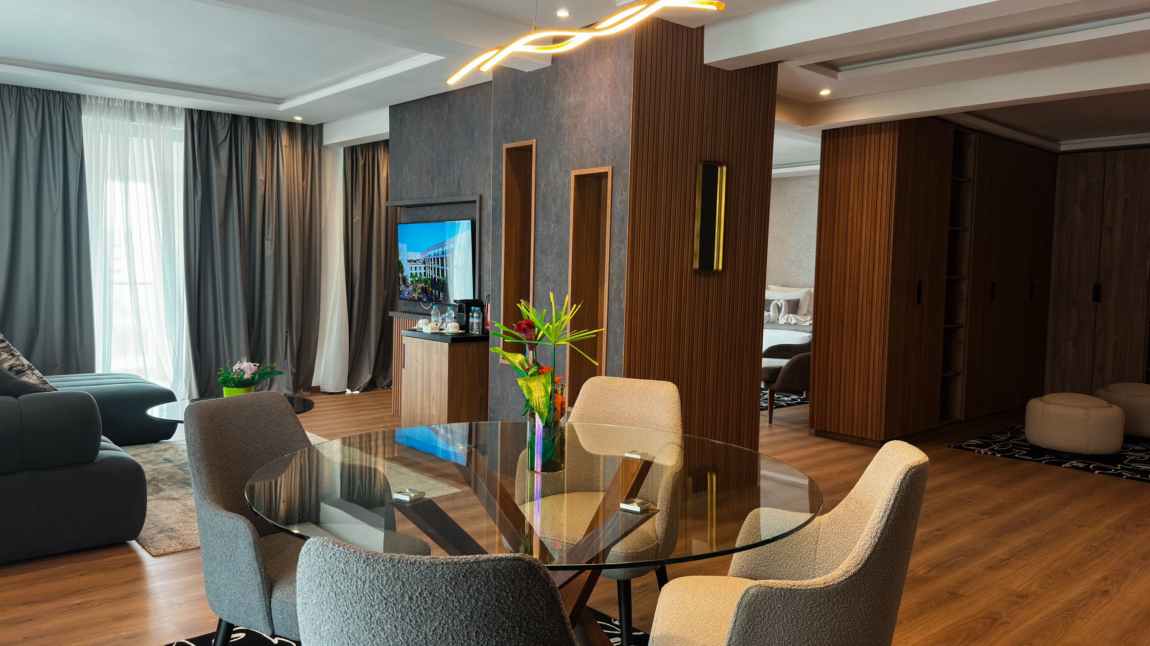 A modern living room with a glass-top coffee table, comfortable seating, and a decorative vase.