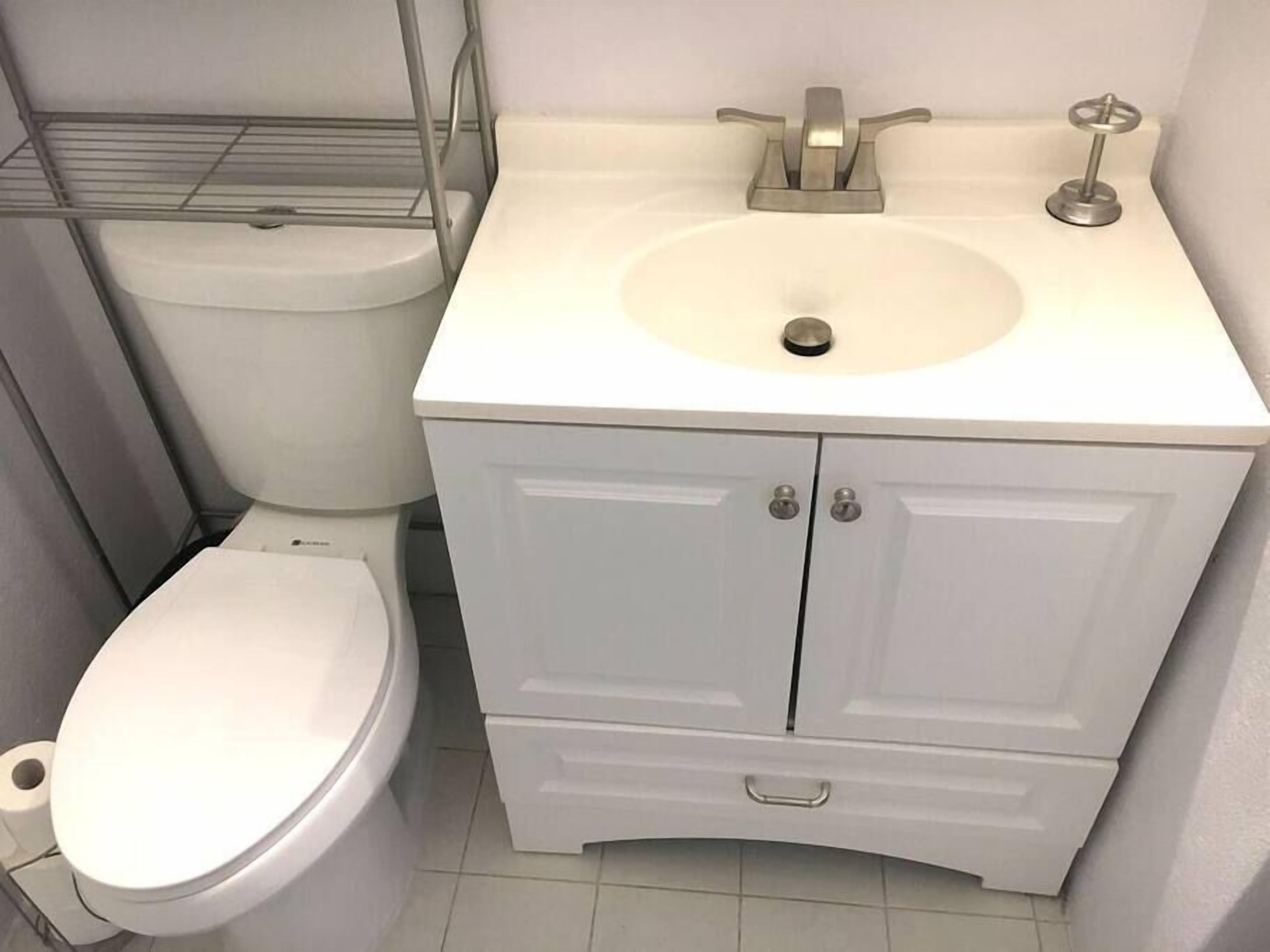 Kylpyhuone, jossa on wc, pesuallas ja kaappi.