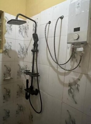 Chuveiro, toalhas de banho, sabonete, papel higiênico