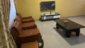 A living room with a sofa set, a coffee table, and a TV stand. - Naayina Vacation Villas #AS178
Your Home away from Home (Northern Region)
