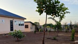 A building with a flat roof and a small garden area with young trees. - Naayina Vacation Villas #AS178
Your Home away from Home (Northern Region)