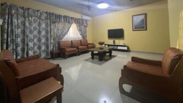 A living room with a sofa set, a coffee table, a flat-screen TV, and a painting on the wall. - Naayina Vacation Villas #AS178
Your Home away from Home (Northern Region)