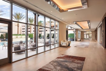 A modern hotel lobby with a fireplace, seating area, and a bar. at Caesars Republic Scottsdale, a Hilton Hotel