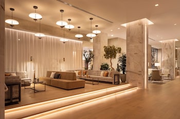 A modern interior with a glass staircase, wooden flooring, and potted plants. at Caesars Republic Scottsdale, a Hilton Hotel