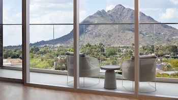 A modern kitchen with a central island, bar stools, pendant lighting, and a wine rack. at Caesars Republic Scottsdale, a Hilton Hotel