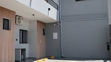 En modern byggnad med ett platt tak, en balkong och en garageport.