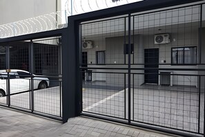 A modern building with large glass windows and a metal fence. - Xavi Studio (Bauru)