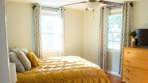 A bedroom with a bed, a ceiling fan, a dresser, and curtains. - HOT TUB 1 2MI to ND Espresso Maker Coffee Bar (South Bend)