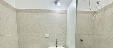 Un baño con inodoro, lavabo y ducha.