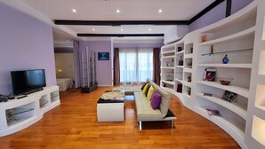 A modern living room with a sofa, ottoman, and entertainment unit. - Attico Coloseo with rooftop (Roma)