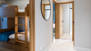 A room with a bunk bed, a mirror, and a door leading to another room. - Downtown Cannes, Apartment with Garden (Cannes)