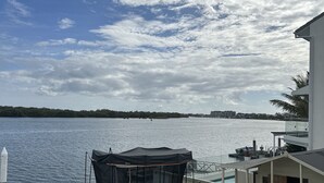 Un balcon donnant sur un lac, un toboggan rouge et une tente noire.
