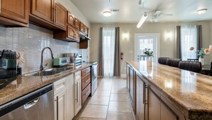 A modern kitchen with granite countertops, stainless steel appliances, and wooden cabinets. - Spacious Urban Living Near French Quarter (New Orleans)