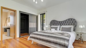A bedroom with a large bed, a wardrobe, and a mirror. - Countryside Charm  (Camara de Lobos)