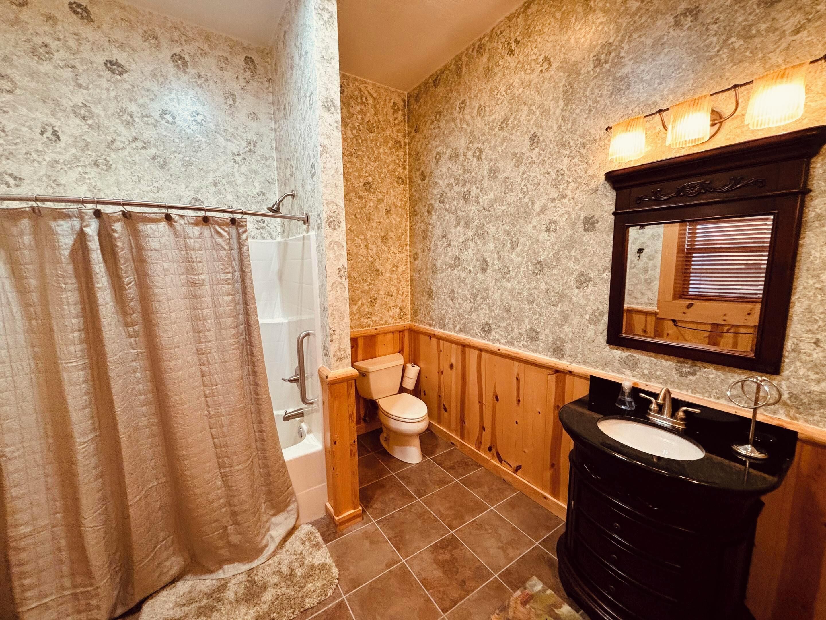 A bathroom with a shower, toilet, and sink.