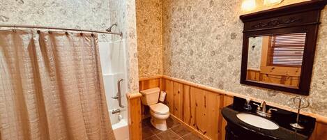A bathroom with a shower, toilet, and sink.